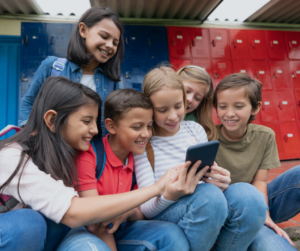 group of kids looking at a cell phone